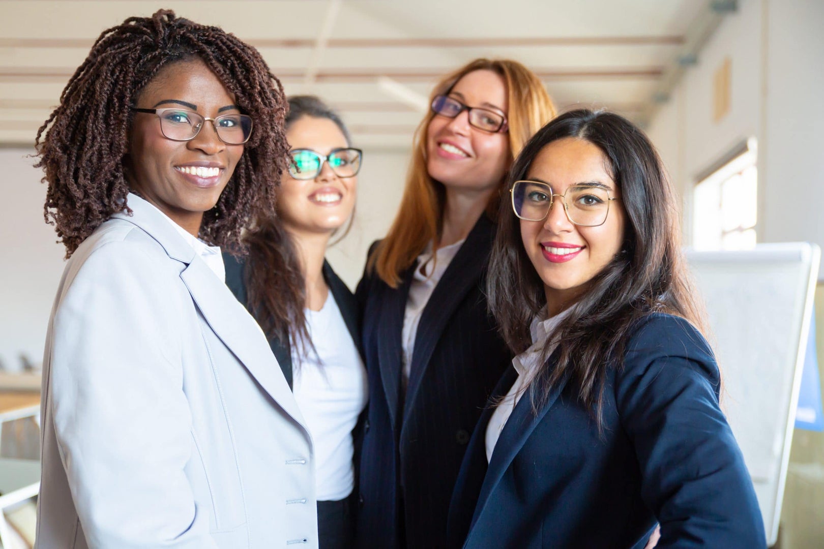 Group of confident young businesswomen looking at camera. Beautiful smiling women posing. Female confidence concept